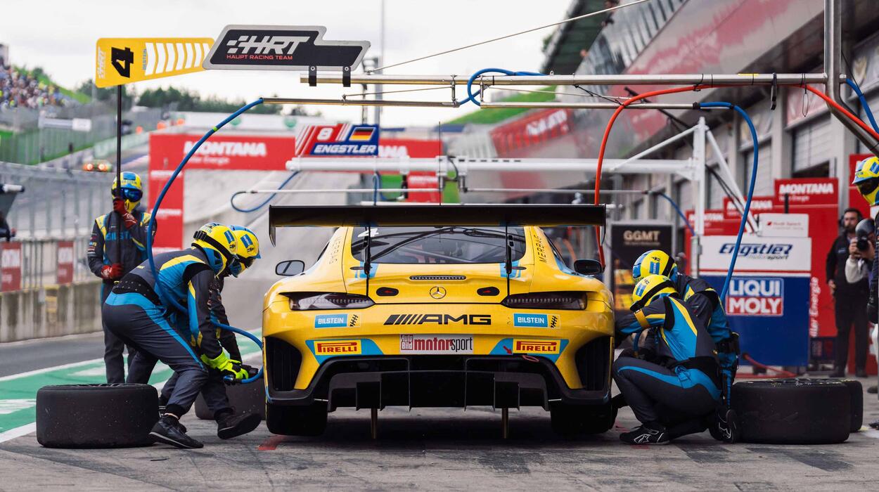 Das von Merbag gesponserte HRT Rennauto beim Reifenwechsel