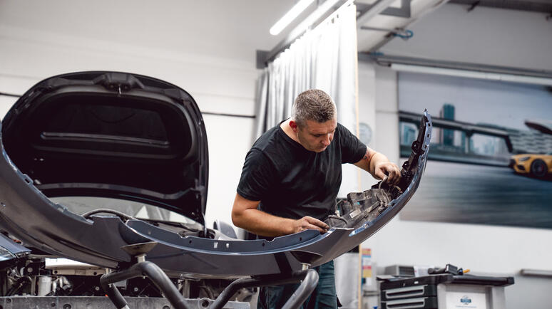 Mechaniker arbeitet an einem Tesla